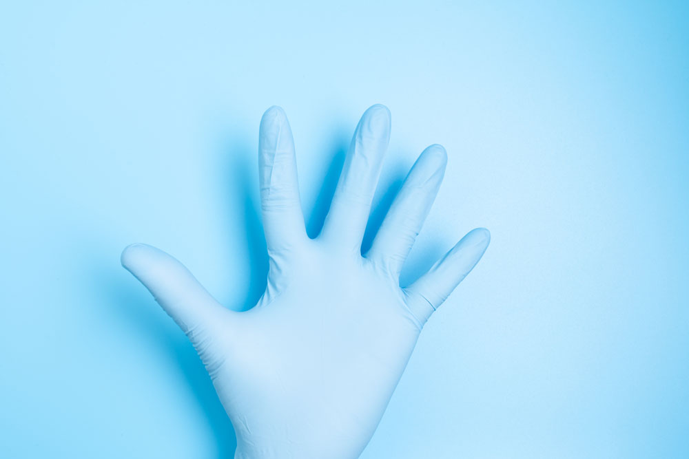 Ausgestreckte Hand in blauem Handschuh auf blauem Hintergrund High Five zeigend