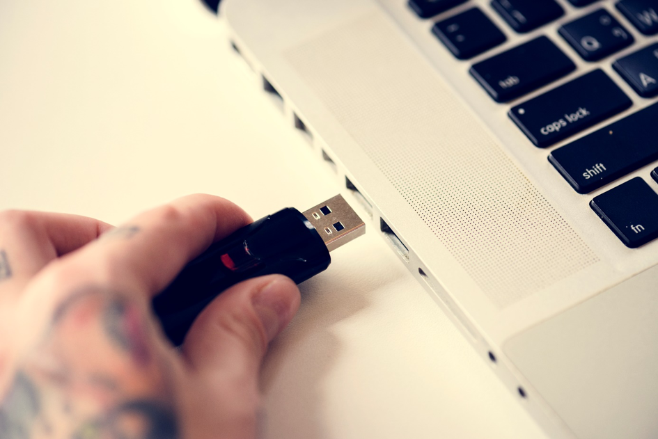 Hand steckt USB Stick in Laptop