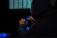 Cyberkriminalitität: Hacker im dunklen Raum am Computer
