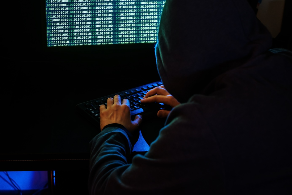 Cyberkriminalitität: Hacker im dunklen Raum am Computer